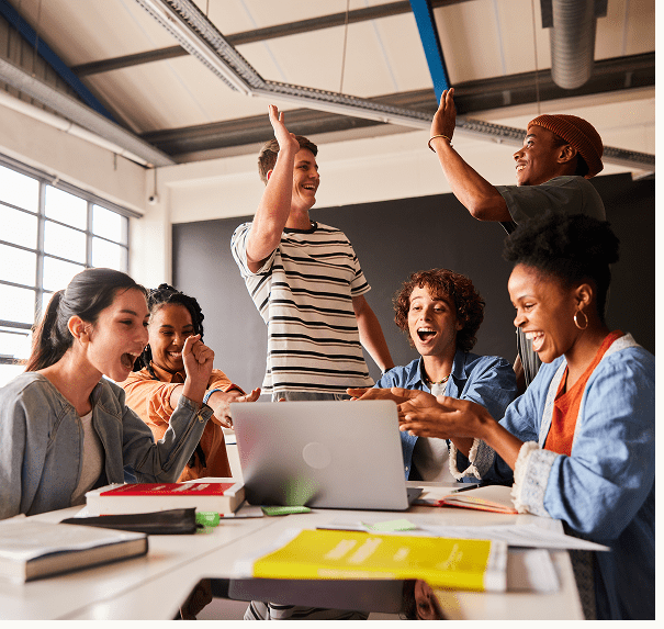 Team celebrating success around a laptop